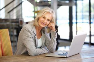 Portrait of beautiful older woman working laptop computer