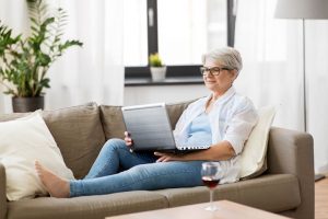 happy senior woman in glasses with laptop computer